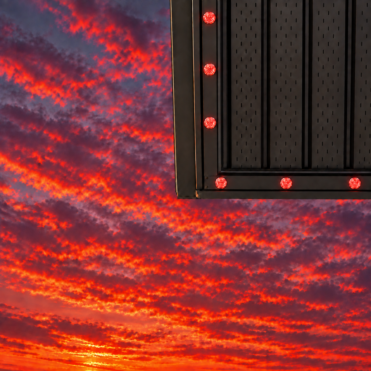 Roofline lighting track with red lights against a sunset sky