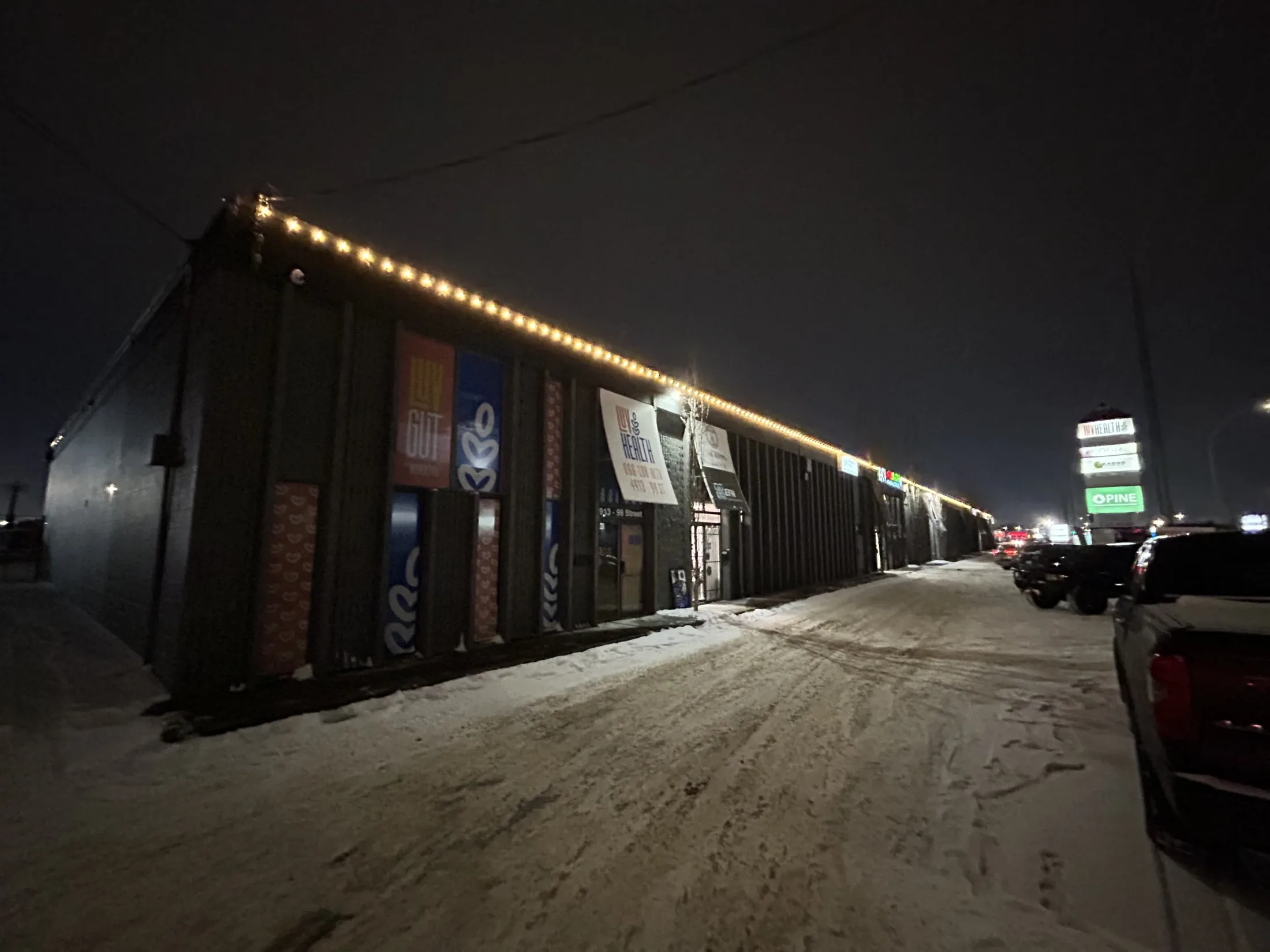 Long commercial roofline with warm Christmas lights at a Coronado Asset Management property